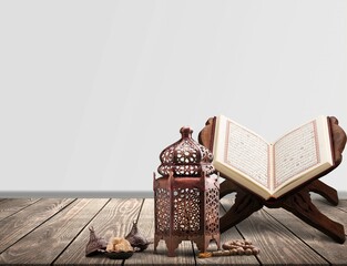 The Holy Al Quran with written Arabic calligraphy on a desk
