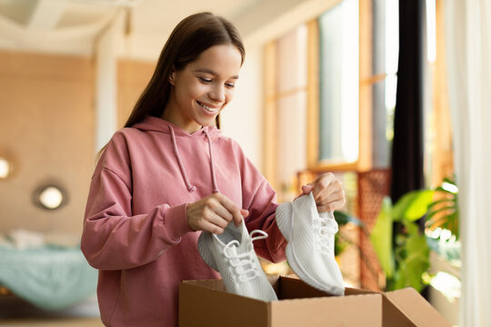 Happy Teen Girl Buyer Holding New Footwear Unpacking Cardboard Box, Receiving Shoes After Successful Online Shopping