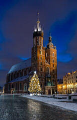 Fototapeta na wymiar St Mary's church on snow covered Main Square in winter Krakow, illuminated in the night.