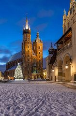 Fototapeta na wymiar St Mary's church and Cloth Hall on snow covered Main Square in winter Krakow, illuminated in the night