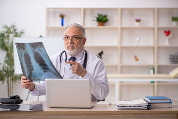 Old male doctor radiologist working in the clinic