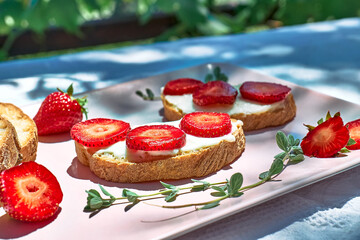 Woman making summer strawberry sandwich. Female hands cutting bread for toast. Healthy eating, fruit dieting brunch.
