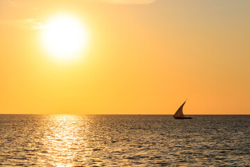 Obraz na płótnie Canvas Silhouette of traditional wooden dhow boat in the Indian ocean at sunset in Zanzibar, Tanzania