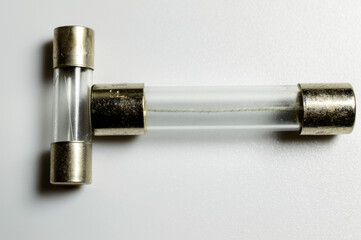 Small pile of clear electrical fuses on a white background. Set of glass fuses with filament inside. Macro picture. Current protection for electric circuits.