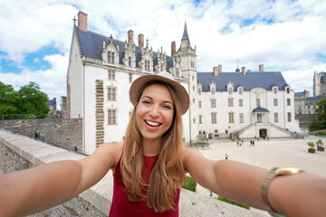 Self portrait of happy traveler girl visiting Nantes Castle, France