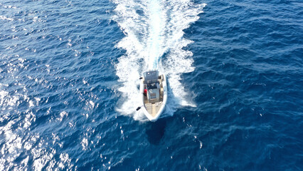 Aerial drone photo of luxury rigid inflatable speed boat cruising in high speed in Aegean deep blue...