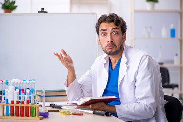 Young male chemist working at the lab
