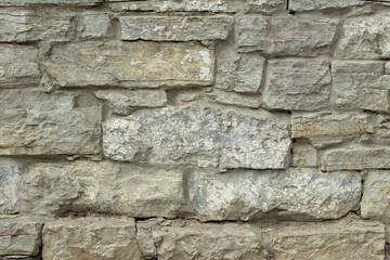 Old gray stone wall. Stone background from gray old stones.