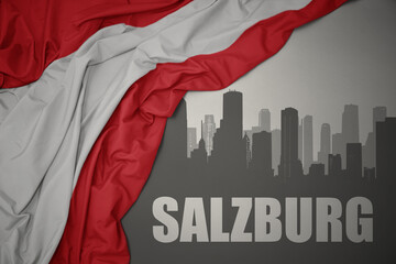 abstract silhouette of the city with text Salzburg near waving national flag of austria on a gray background.