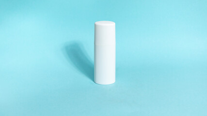 One white tube of skin care cosmetics on blue background. The concept of face and body skin care and anti-aging treatments.