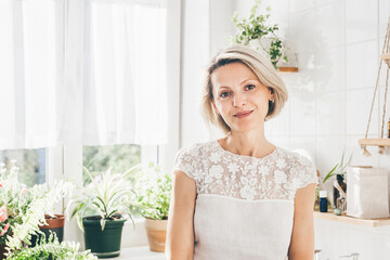 Portrait of beautiful middle-aged woman in white bathroom. Wellness, self care, comfort zone
