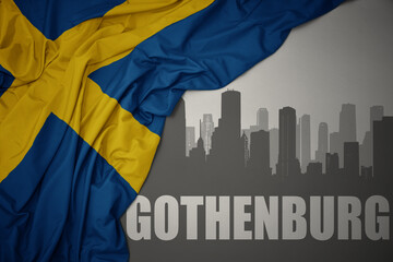 abstract silhouette of the city with text Gothenburg near waving national flag of sweden on a gray background.