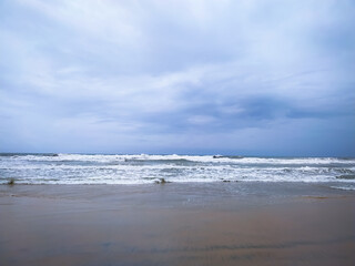 Soft wave of sea on the sand beach with cloudy sky