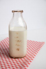 Jar of milk on a red checkered tablecloth, white background