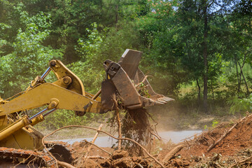 Fototapeta premium Land cleared from roots for housing development subdivision using tractors skid steers