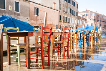 Colorful chairs in a row along Venetian canal