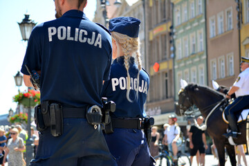 Blond policjantka w niebieskim mundurze na służbie.