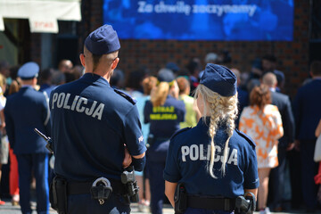 Blond policjantka w niebieskim mundurze na służbie. - obrazy, fototapety, plakaty