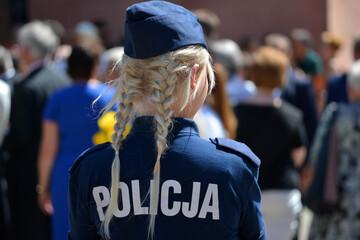 Blond policjantka w niebieskim mundurze na służbie. - obrazy, fototapety, plakaty