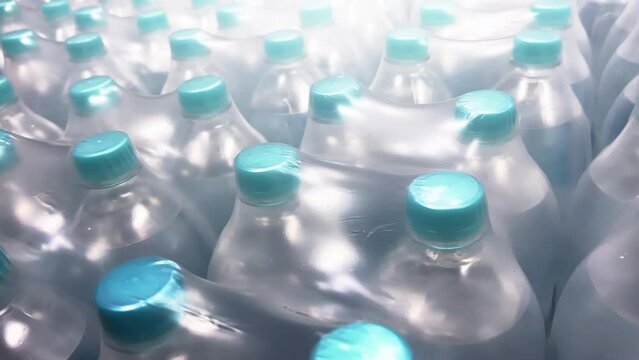 Two-liter bottles of mineral water packed in 6 bottles stand in warehouse. Close-up shot.