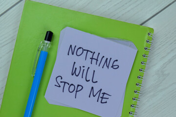 Concept of Nothing Will Stop Me write on sticky notes isolated on Wooden Table.