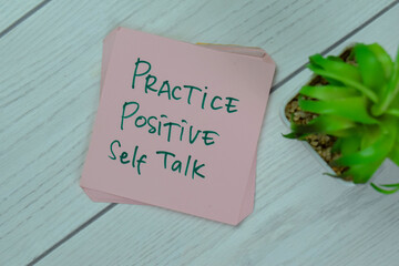 Concept of Practice Positive Self Talk write on sticky notes isolated on Wooden Table.