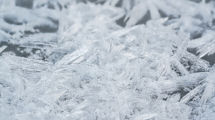 Ice and snow crystals forming spike shapes on frozen river, closeup macro detail, abstract winter...