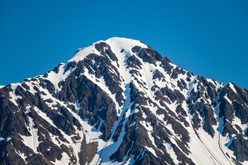 Fototapeta na wymiar Snow covered peak of the mountain overlooking the port of Seward in Alaska