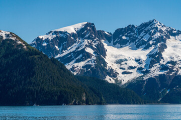 Fishing boats in the bay under snow covered peak of the mountain near the port of Seward in Alaska