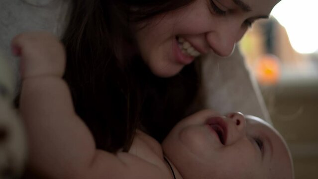 Newborn Baby With Young Mom look Into Each Other Eye. Cute Smiling Teethless Kid Face Portrait. Woman Kissing With Child Look At Camera. Infant, Mother Day, Childbirth, Beginning, Relationship Concept
