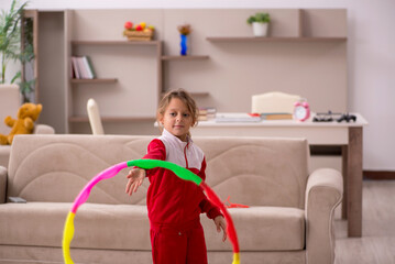 Young little girl doing sport exercises at home © Elnur