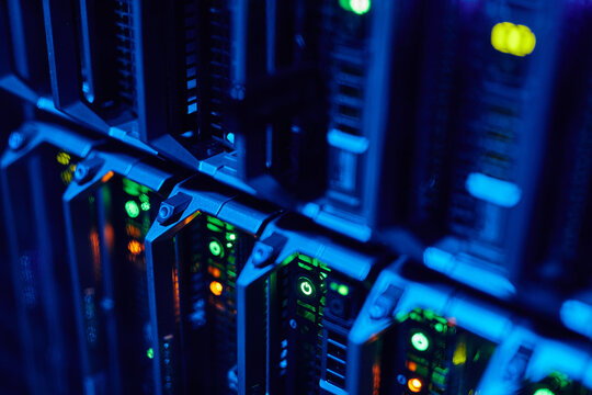 Macro image of blade servers in blue neon light stacked in data center, copy space