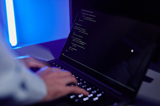 Close up of IT engineer writing code at laptop and setting up server network, copy space