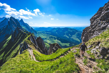 Obraz premium Hiker is walking along the a beautiful altitude path