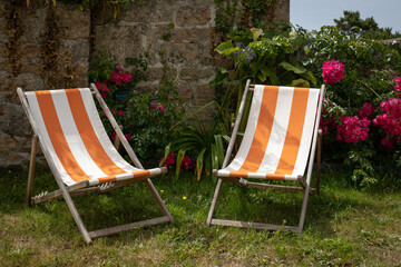 deux chaises longues dans un joli jardin fleuri ensoleillé