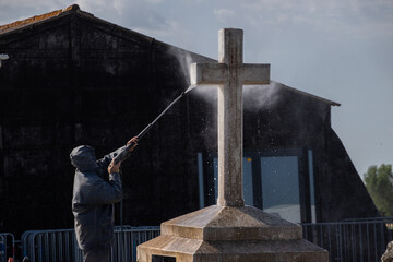 homme nettoyant la croix avec un nettoyeur à haute pression. 