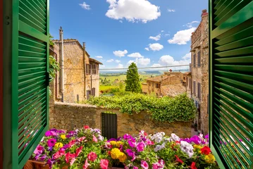 Peel and stick wall murals Toscane View through an open window with shutters out over the Tuscan countryside and medieval hilltop old town of San Gimignano, Italy.