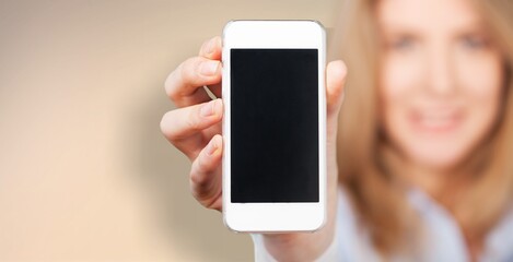 Stylish smiling woman showing smartphone blank screen, mobile app interface