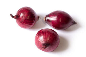 three red onions lie on a white background