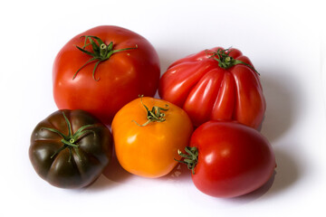 multi-colored tomatoes lie on a white background