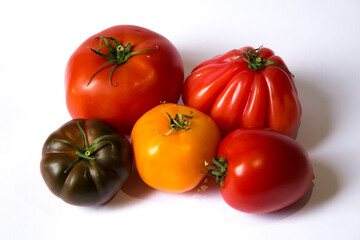 multi-colored tomatoes lie on a white background