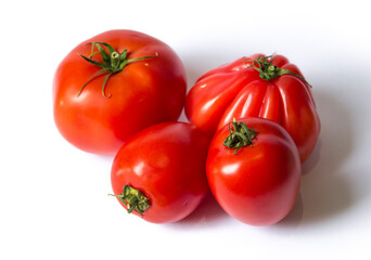 four fresh red tomatoes lie on a white background