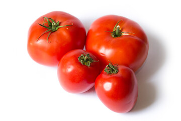 four fresh red tomatoes lie on a white background