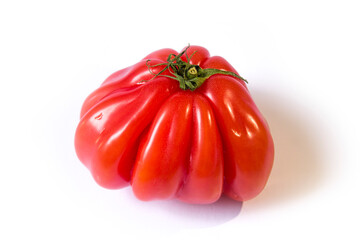 a red crinkled tomato lies on a white background