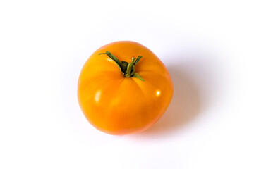 yellow tomato lies on a white background