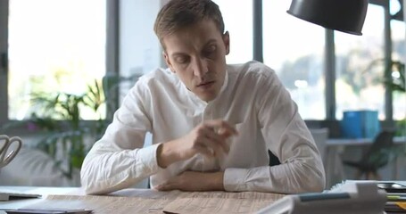Businessman sitting at desk and reading a newspaper