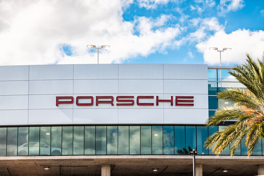 Orlando, USA - October 19, 2021: Porsche brand car auto dealer dealership building facade sign with indoor parking lot for cars in Florida selling new cars
