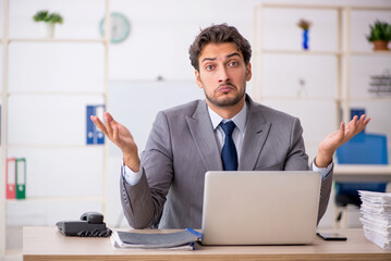 Young male employee sitting at workplace