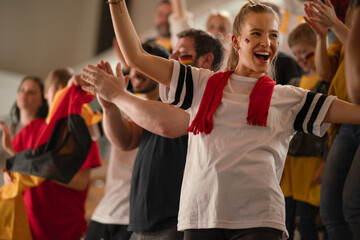 Fototapeta premium Football fans supproting German national team in live soccer match at stadium.
