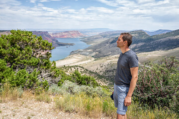 Man standing looking at view over Sheep Creek Overlook in Manila, Utah near Flaming Gorge National...